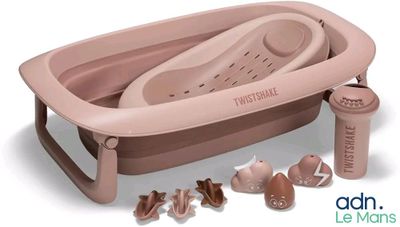 une baignoire rose dans laquelle se trouvent un biberon et d'autres objets