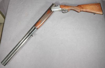 un gros plan d'un fusil à crosse en bois posé sur une chaise