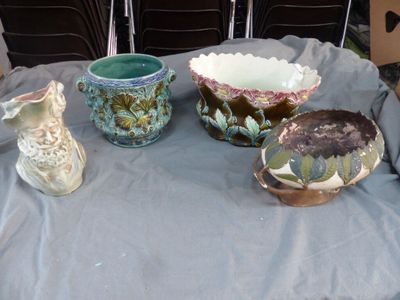 plusieurs vases et bols posés sur une table, avec des chaises en arrière-plan