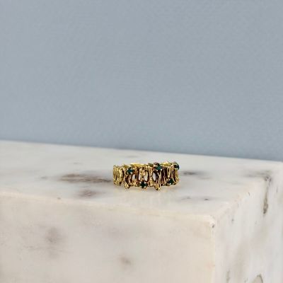 un gros plan d'une bague en or posée sur un bloc de marbre