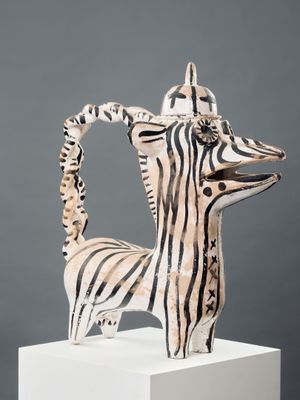 sculpture représentant un zèbre sur un socle blanc, sur fond gris
