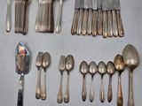 un grand nombre de cuillères et de fourchettes disposées sur une table