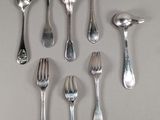 a lot of silver spoons and forks on the table