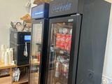 a glass door refrigerator in a kitchen with a basket on top of it