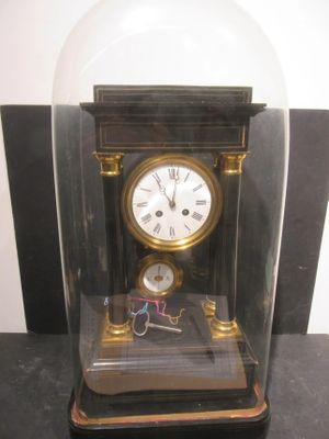 a glass case with a clock inside of it on a table