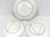 two white plates with gold trims and a white plate with a triangle on it
