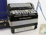 a black and white accordion sitting next to a blue case