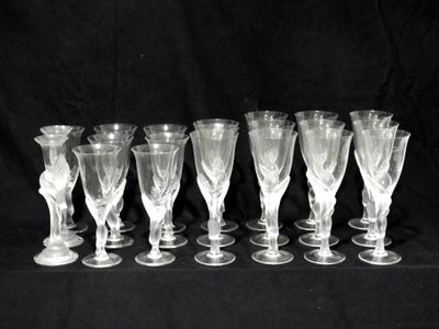 six verres à vin transparents sont alignés sur un fond noir