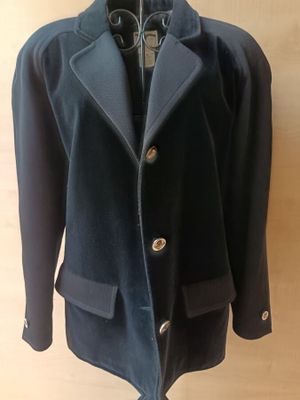 navy blue jacket on a mannequin hanger on a wooden wall