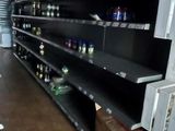 many empty shelves in a store with bottles on them