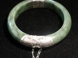un bracelet vert auquel est attachée une chaîne