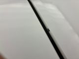 the back of a white cell phone sitting on top of a table