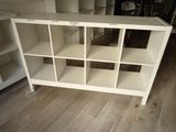 a white bookcase that has many shelves on it