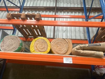 de nombreux rouleaux de papier sur une étagère dans un entrepôt