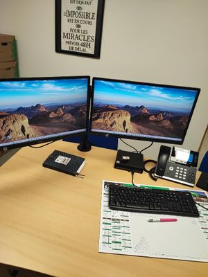 un bureau équipé de deux écrans et d'un clavier