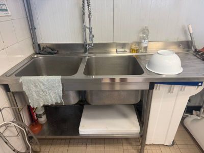 a stainless steel sink in a kitchen with a dishwasher on the counter