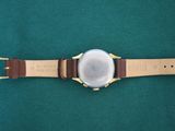 an image of a close up of a watch on a green surface