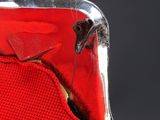 a close up of a red chair with a bird on it ' s back