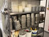 many pots and pans on the shelf in the kitchen