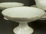 several white and gold decorated bowls and bowls on a table