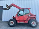 a red tractor that is parked in front of a building