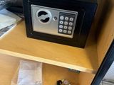 un petit coffre-fort posé sur une étagère dans une pièce