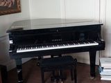 a piano in the corner of a room with a rug on the floor
