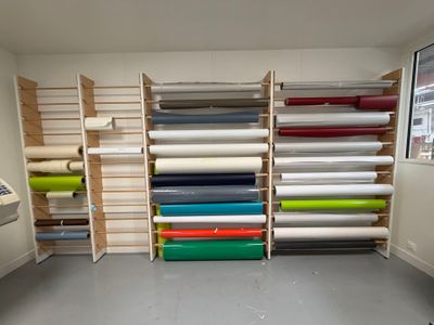 many rolls of fabric on the shelves in the room