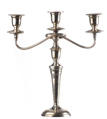 une image représentant un chandelier en argent sur lequel sont disposées trois bougies