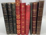 several old books are lined up in a row on a table