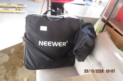 un sac noir posé sur un canapé, à côté d'un fauteuil rouge