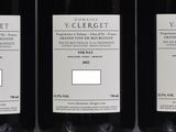 three bottles of red wine sitting on top of a table