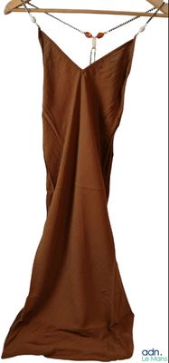 une robe marron suspendue à un portant, sur un cintre en bois