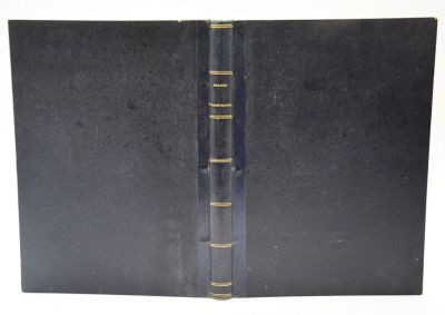 un vieux livre noir avec des bordures dorées sur fond blanc