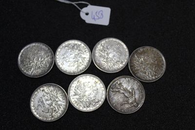 six silver coins with a price tag on a black surface