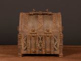 a small wooden chest on a table with a black background