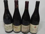 four bottles of wine are lined up on a table