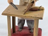 a figurine of a man with a knife on a table