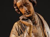 wooden statue of a man holding a book and a book