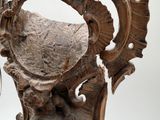 a wooden sculpture of a man and a woman sitting on a chair