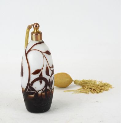 une bouteille en verre blanche et marron avec une poignée dorée