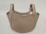 un petit sac à main beige muni d'une anse, sur fond blanc