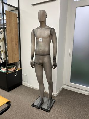 un mannequin au milieu d'une pièce, avec un bureau en arrière-plan