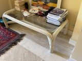 a glass coffee table with books on it in a living room