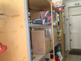 a room with several shelves and red chairs in it