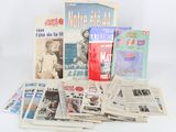 several newspapers are stacked on top of each other on a white surface
