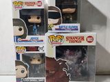 trois figurines Funko Pop en vinyle, dans leurs boîtes, posées sur une surface blanche