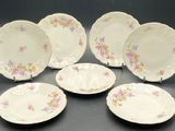 six assiettes en porcelaine ornées de motifs floraux, posées sur une table