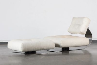 une image représentant une chaise et un pouf dans une pièce aux murs blancs