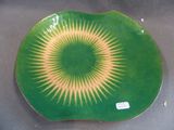 a green plate with a yellow and white design on it